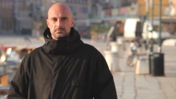 Man In Black Jacket Walking Along Harbour