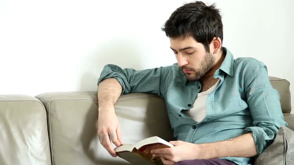 Man Sitting In Living Room Reading Interesting Novel