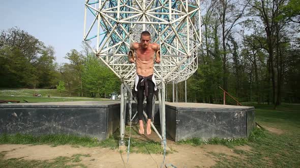 Muscular Man Doing Pull-Ups On Gymnastics Rings