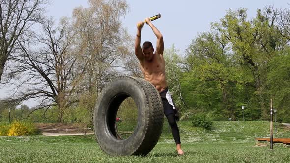 Muscular Man Hitting Standing Tire With A Hammer 2 alt