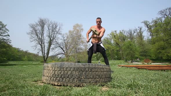 Muscular Man Hitting Tire With A Hammer 1