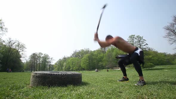 Muscular Man Hitting Tire With A Hammer 2