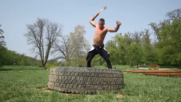 Muscular Man Hitting Tire With A Hammer, Changing Hands alt