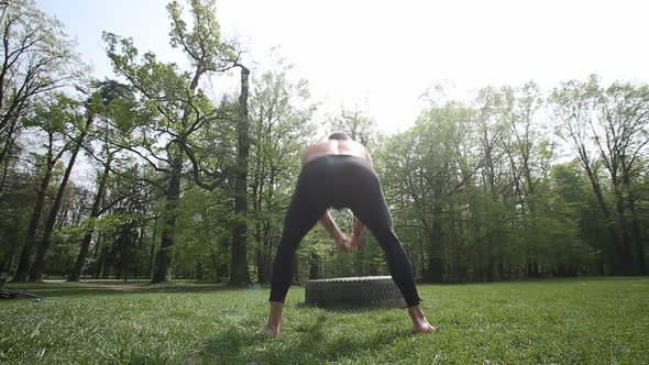 Muscular Man Hitting Tire With A Hammer, Shoot From Behind 1