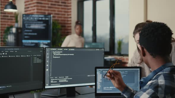 Programmer Analyzing Compiling Code on Multiple Screens Takes Off Glasses and Doing High Five Hand