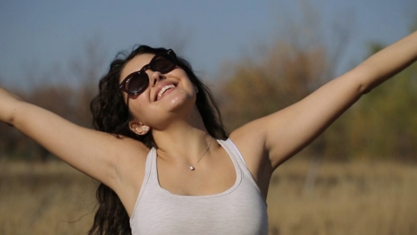 Woman With Arms Outstretched In a Wheat Field