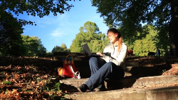 Young Woman Working Outdoors On a Laptop