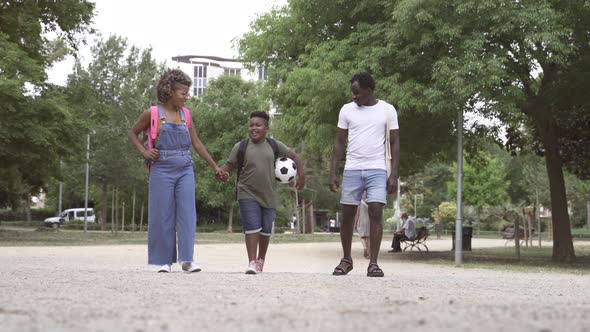 African American Parents Walking Take Child Back to Elementary School