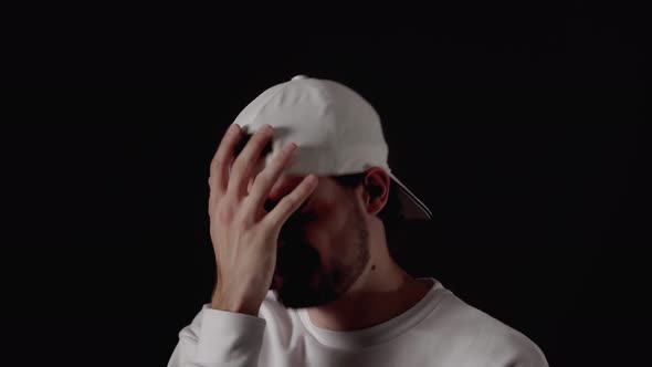Trendy 20s Man shaking head giving extreme facepalm, close, black background