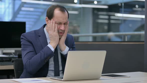 Businessman Reacting to Loss While Using Laptop