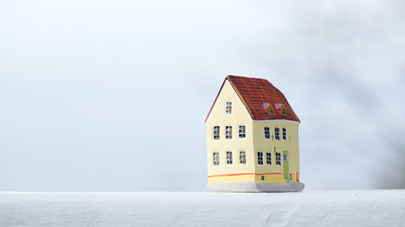 Putting a Small Toy House On The Table alt