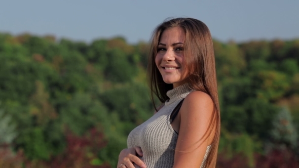 Happy Young Pregnant Woman Smiling At The Camera