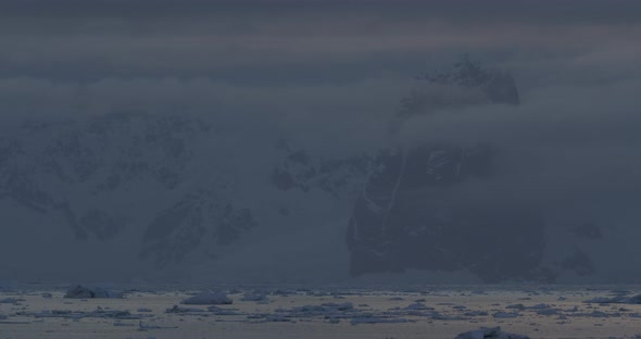 Iceberg at sunset with island on the background