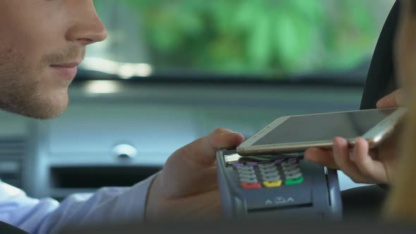 Woman Paying for Taxi Ride via Application on Smartphone, Contactless Payment