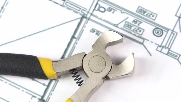 Wire Cutters with Yellow, Gray Handle on Building Plan, Scheme, Rotation, Close Up