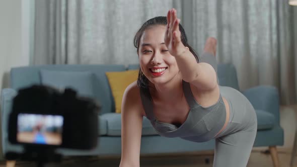 Trainer Female In Sports Clothes Speaking To Camera And Doing Yoga In Balancing Table Pose