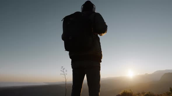 Silhouette of a Young Explorer in the Mountains at Sunset