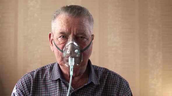 The Old Man Putting on the Breathing Mask and Makes Few Deep Breaths