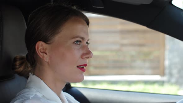 Portrait of Woman Talking on Speakerphone in Car