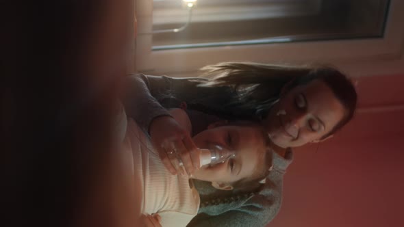 Verticaal Closeup Portrait of Beautiful Little Girl Making Inhalation Using a Compressor Inhaler