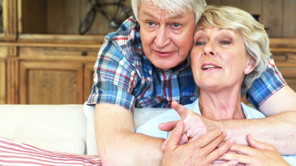 Senior couple watching tv together in living room