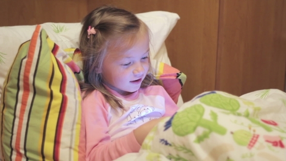 Little Girl With The Tablet On The Bed Singing a