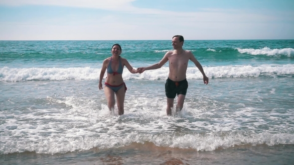 Happy Couple Having Fun On Ocean Waves