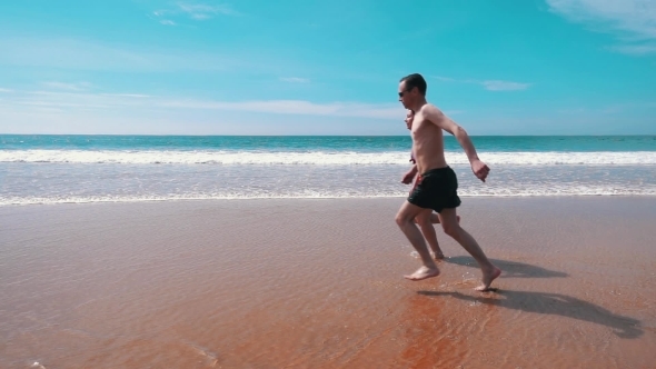 Happy Couple Running On Beach