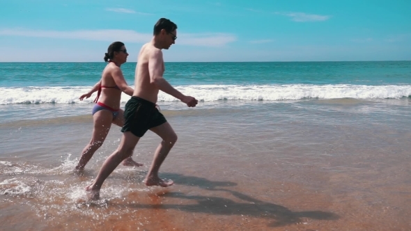 Happy Couple Running On Beach