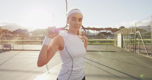 Video of caucasian female tennis player holding racket and looking at camera