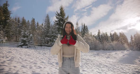 Woman in Winter Clothes Thumbs Up in Front of Mountain Forest Outdoors