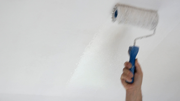 Man Painting Ceiling With Roller