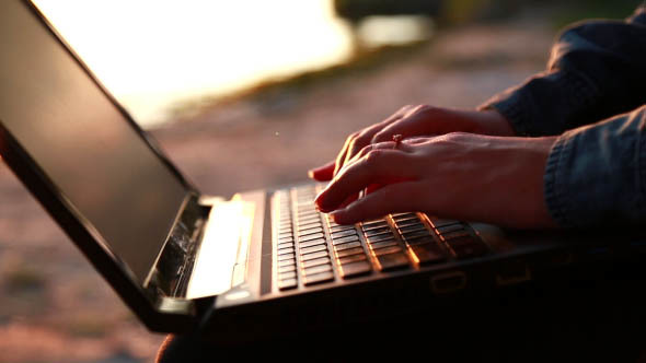 Girl Prints the Report on a Laptop