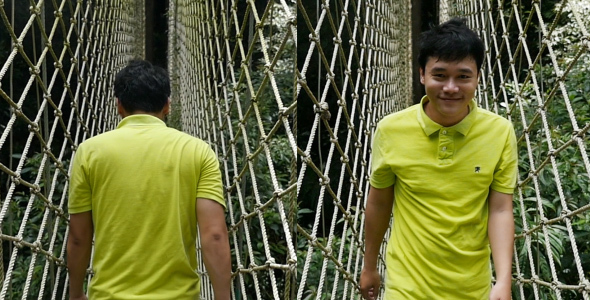 Asian Man Walking on Suspension Bridge