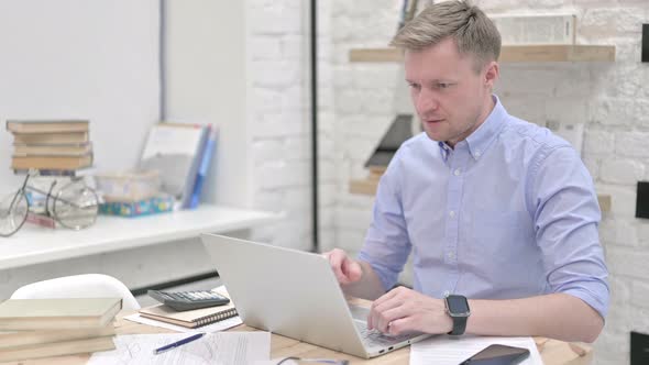 Businessman Celebrating While Working on Laptop