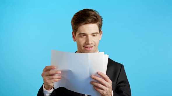 Young Handsome Man in Suit Jacket Checks Documents, Utility Bills, Report. Businessman Isolated on