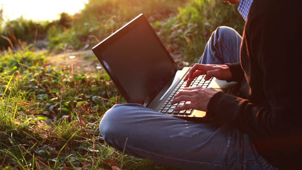 Man Uses a Laptop on Nature