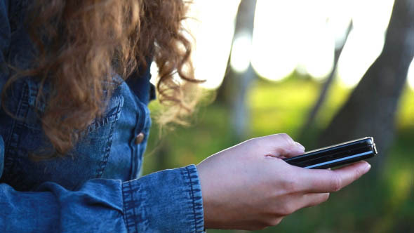 Girl on Nature Uses the Phone