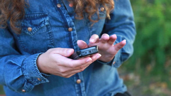 Woman on Nature Uses the Phone alt