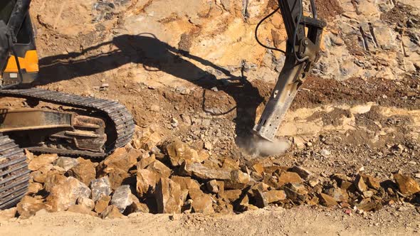 Excavator with Hydraulic Hammer Crushes Rocky Soil