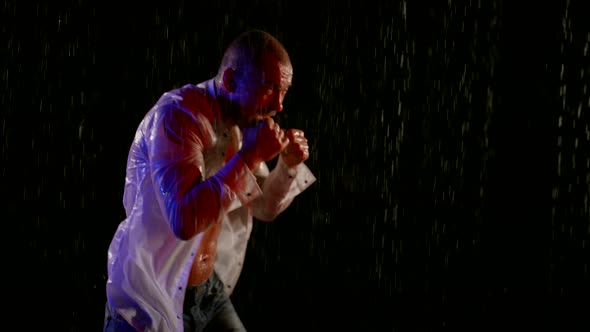 Mad Man is Shouting and Punching Rain Drops in Night Single Furious Fighter in Rain