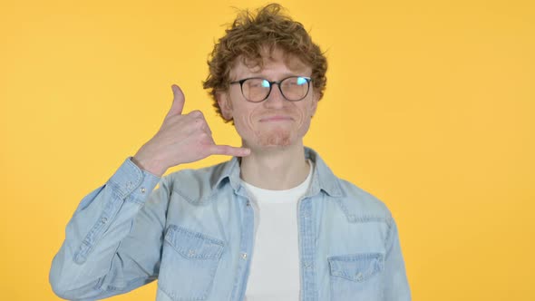 Call Me Gesture By Redhead Young Man, Yellow Background