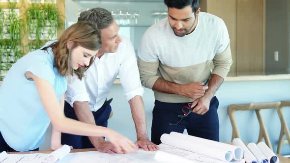 Business people working on blueprint at table in a modern office 4k