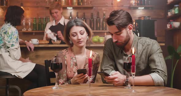 A Young Numb Couple Distracted By Social Media While on a Date