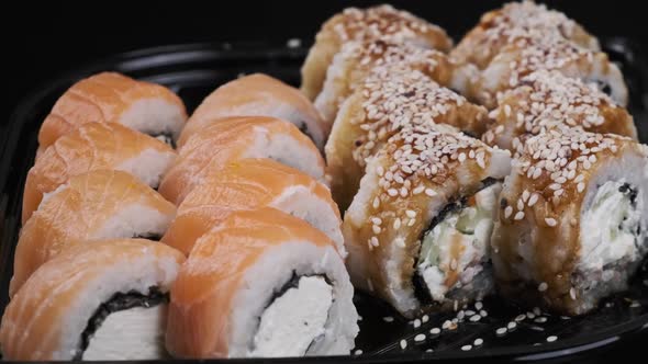 Sushi Rolls Rotating in Plastic Box