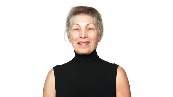 Older Woman with Grey Tied Hair Looking at Camera Smiling Laughing with White Teeth Over White