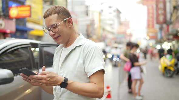 4K Asian man using smartphone while traveling at street night market in Bangkok city, Thailand