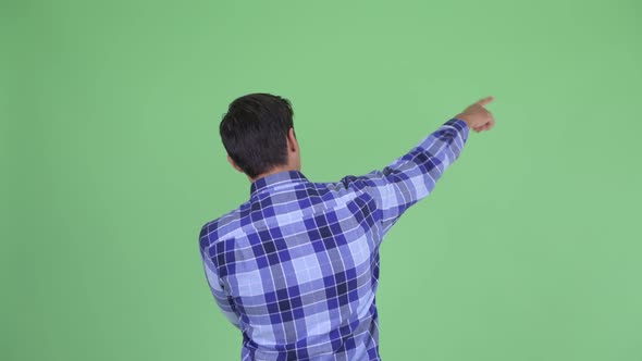 Rear View of Young Hipster Man Pointing Finger