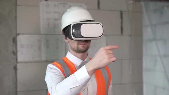 A civil engineer analyzes the work of builders using virtual reality glasses.