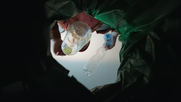 Man Throwing a Plastic Bottle Into a Trash Bin